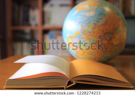 Close-up of books opened on library table The globe is the background selective focus and shallow depth of field