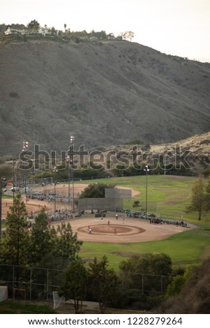 Drone view of a sports field complex with youth softball players, in a California valley, with space for text on top