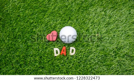 Dad with golf ball and tee with love on green grass