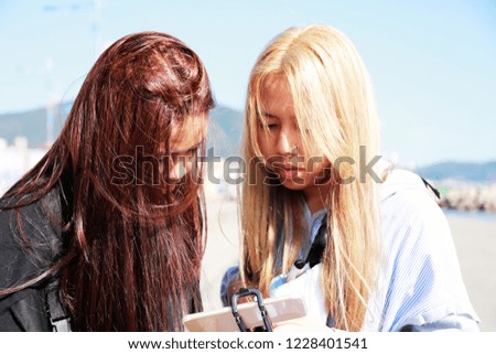 teenagers blond hair girl and red hair looking at smartphone