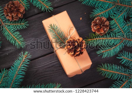 Christmas gift boxes and fir tree branch on wooden table.