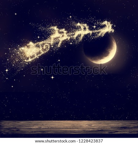 Santa flying on night sky over moon light. Merry Christmas and happy holiday. Elements of this image furnished by NASA