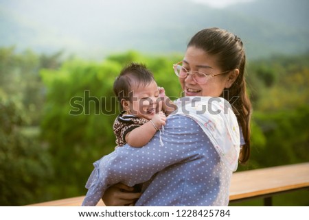 Portrait of happy loving mom with her baby in outdoors.