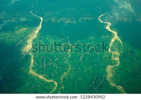 green fields with two river channel and villages from a great height.  air photography