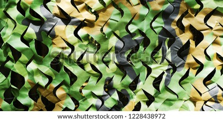 Camouflage netting background blends in with woods and jungle. 