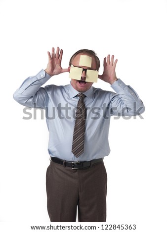 Businessman with stick notes on face teasing over white background