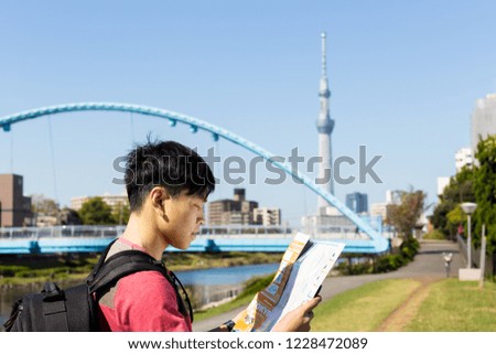 Asian Traveller looking in the map of tokyo,Japan
