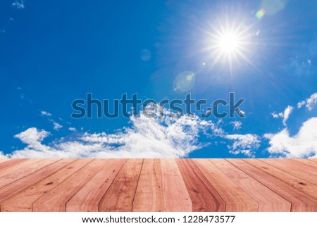 A picture of a wooden desk in front of an abstract sky background.
