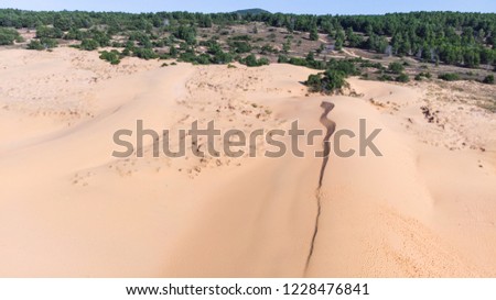 Stunning wide angle aerial drone view of beautiful white sand dune. Background texture of desert sand dunes from high angle. Aerial top vertical shot of sandy desert at Red Sand Dunes Mui Ne, Vietnam