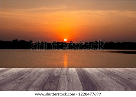 A picture of a wooden desk in front of an abstract background of sunset.