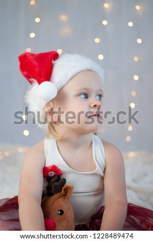 Cute blonde toddler girl wearing Santa hat at Christmas time in Australia during summer