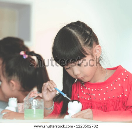 Asian girl and boys is painting on dolls in Art group