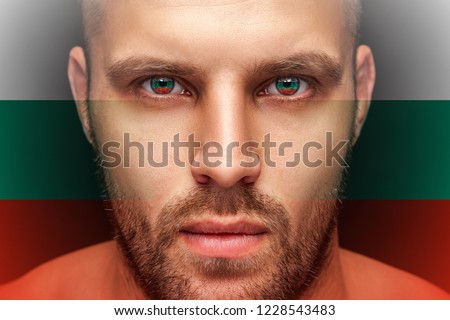 Portrait of a young serious man, in whose eyes the reflected national flag of Bulgaria, against an isolated black background and flag