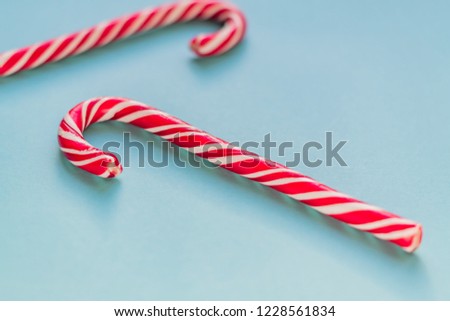 Merry Christmas and Happy New Year greeting card. Two candy canes on blue background with copy space for your text.