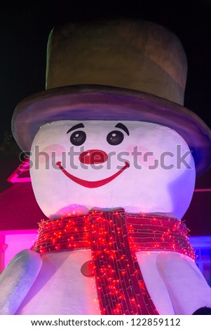 snowman behind christmas tree gifts