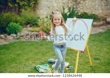 Beauty little girl painting. Cute little lady in a summer garden. 