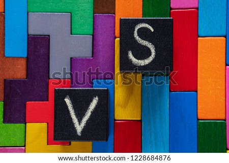 Letters VS on colorful wooden background with copy space. The concept of making choice. Versus concept. Black cubes with letters VS. 