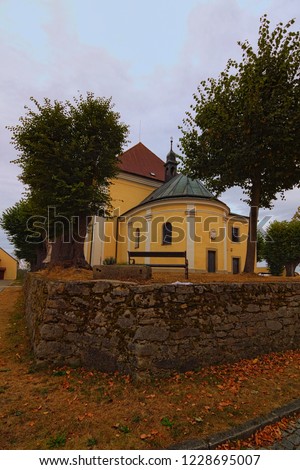 Scenic landscape view of Church of Our Lady of Carmel is surrounded by trees. Kostelni Vydri village in cloudy summer day. South Bohemian Region, Czech Republic.