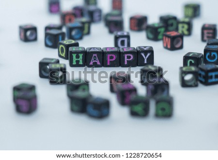 
scattered letters on a white background. composed the word from cubes. happy lined up with beads. word game.