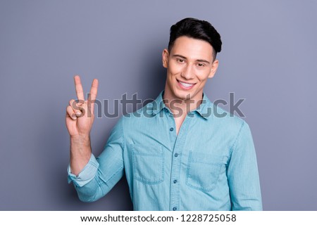 Portrait of nice cheerful attractive handsome classy man in blue formal shirt white beaming smile showing v-sign isolated over pastel violet background