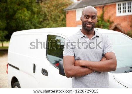 Young black adult tradesman standing next to his white van, close up, close up Royalty-Free Stock Photo #1228729015