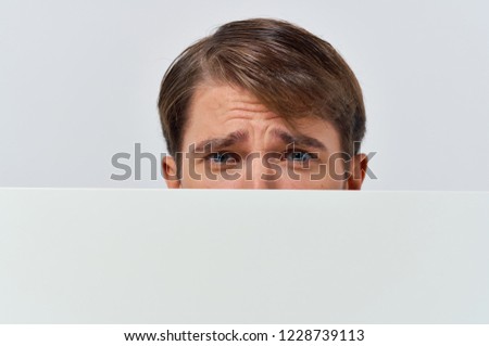  disappointed man behind a white sheet of paper Poster mockup                              