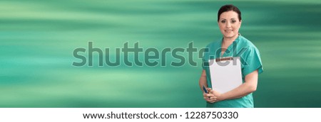Portrait of female doctor holding a clipboard on green background