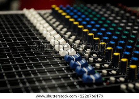 Professional Audio Sound Mixing Console Faders, black desk and white controller Faders with yellow and blue  aux knobs