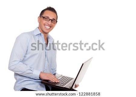 Enthusiastic businessman using a laptop balanced on his arm as he sits on a stool conceptual of the wireless connectivity and portability of the computer as a business tool isolated on white