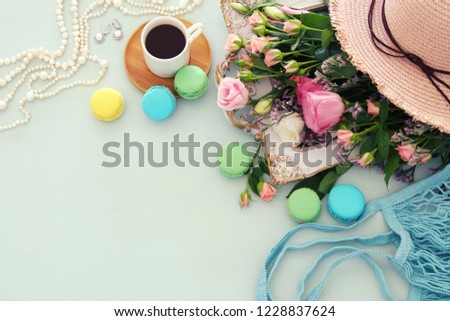 plate of macaroons over wooden table cofee and flowers