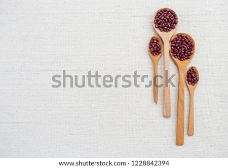 Red beans in design wooden spoon with space on canvas texture background
