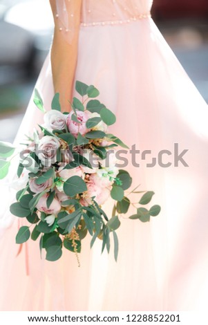 bride's hands hold a beautiful bridal bouquet of roses. fine art photography.