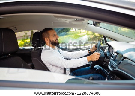 Young businessman driving a car. 