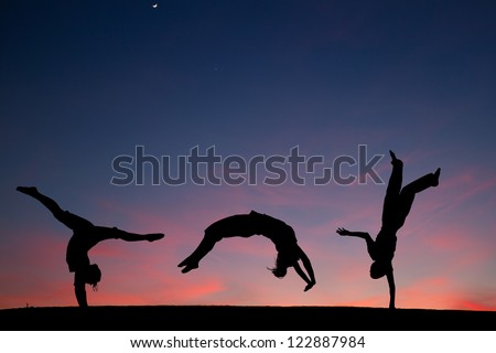 group of gymnasts tumbling in sunset