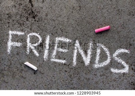 Colorful chalk drawing on asphalt: Word FRIENDS 