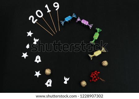 Merry Christmas and Happy New Year decoration on a black background. Text place. Biscuits, fir branch, stars, gifts.