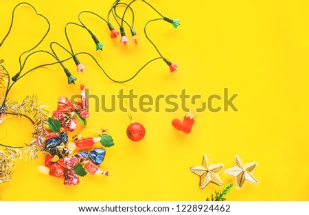 Christmas decoration and lights glowing on yellow background.
