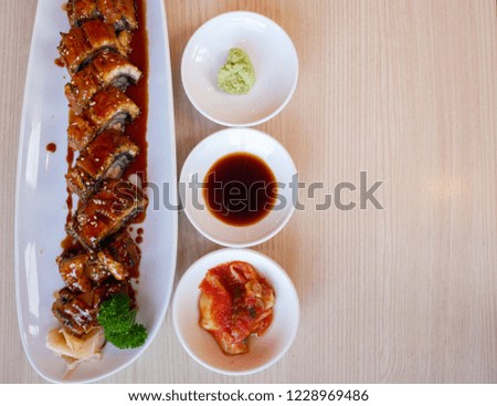 Japanese Food Unagi roll on white dish ,on Wood background ,Top view