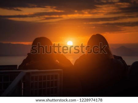 Rear view of Traveler couple woman looking sea at sunset in Shizuoka, Japan.