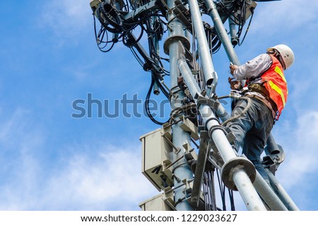 technician working on high telecommunication tower,worker wear Personal Protection Equipment for working high risk work,inspect and maintenance equipment on high tower. Royalty-Free Stock Photo #1229023627