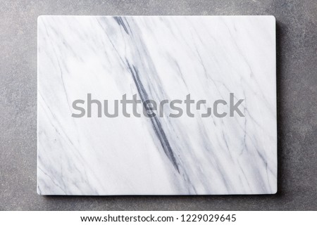 White marble texture board on grey background. Top view. Copy space.