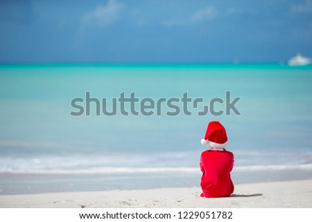 Adorable little girl in Santa hat on Christmas holidays