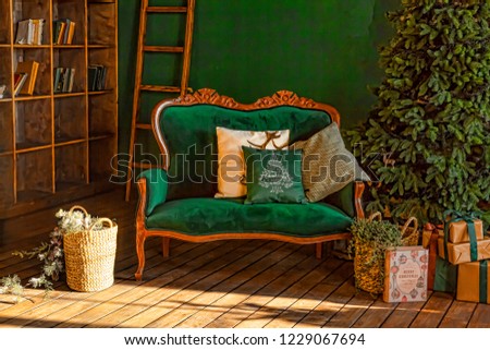 Christmas tree in royal interior. New Year's Living Room with antique stylish green sofa with luxurious golden accessories. Gifts, Christmas decorations.