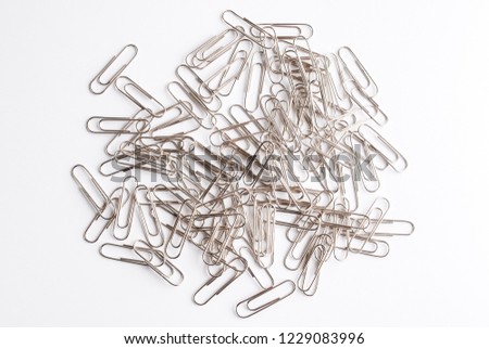 Metal paper clips on white. bunch of clips.