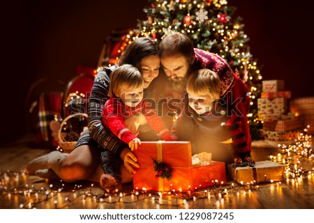 Christmas Family open Lighting Present Gift Box under Xmas Tree, Happy Mother Father Children in Magic Night