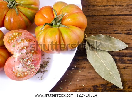 Raff tomatoes on wood table and oregano