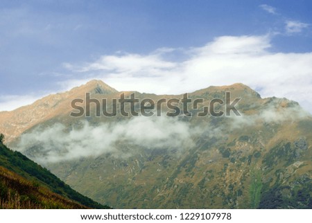 landscape of the Caucasian highlands with a cloud on a hillside