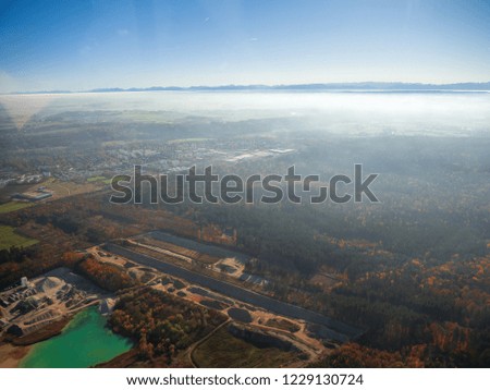 Helicopter view Munich and the area around the city with a stunning morning autumn fog and view to the bavarian alps