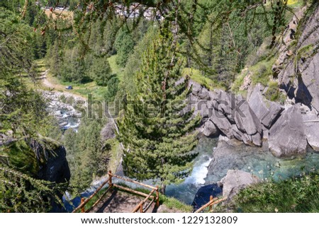 View from above of a mountain waterfall with coniferous forest and hiking trail, Lillaz, Aosta Valley, Alps, Italy Royalty-Free Stock Photo #1229132809