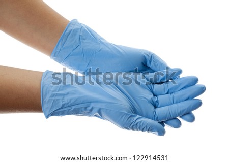 Cropped close-up image of a human hand wearing blue surgical gloves.